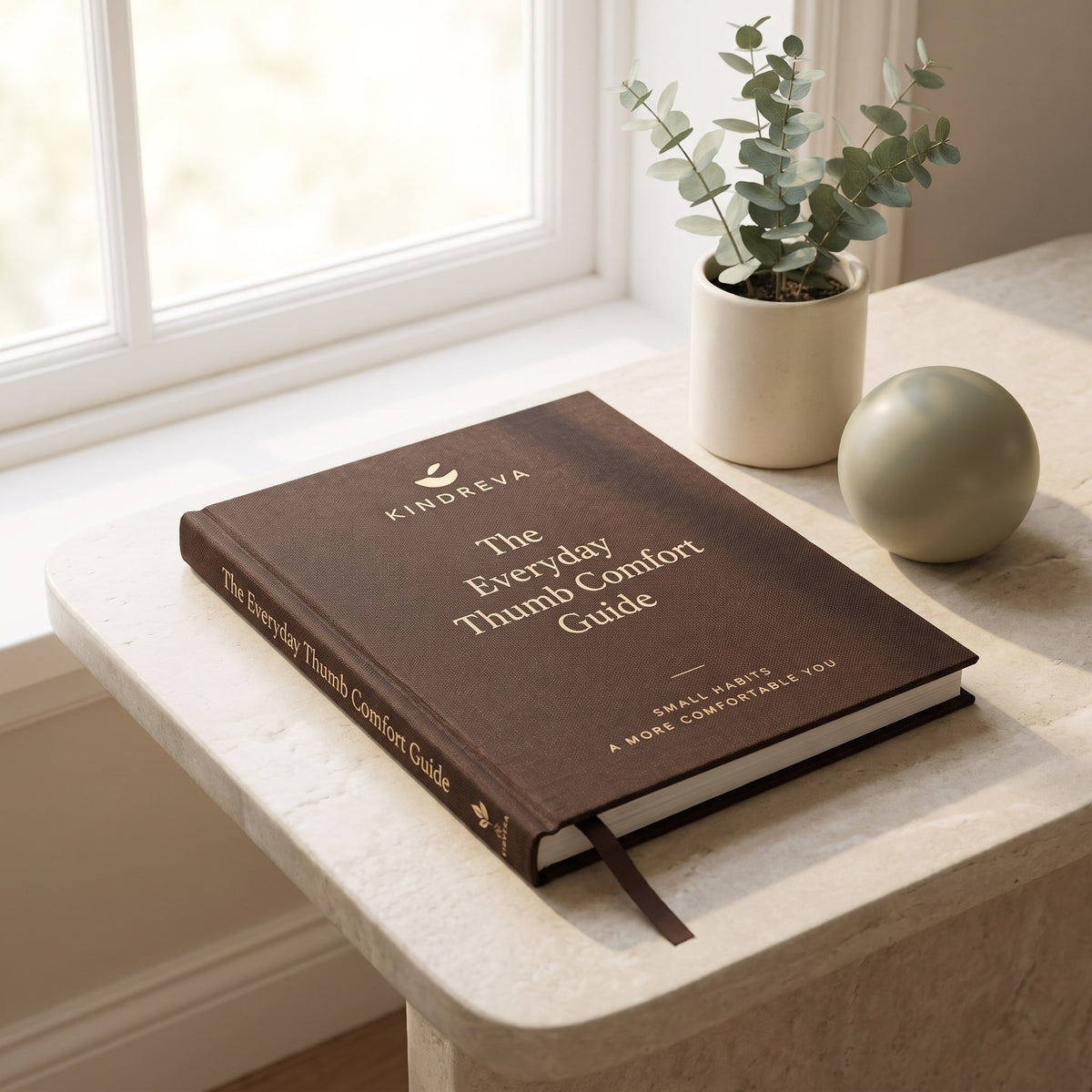 Everyday Thumb Guide by Kindreva, brown cover on a stone side table